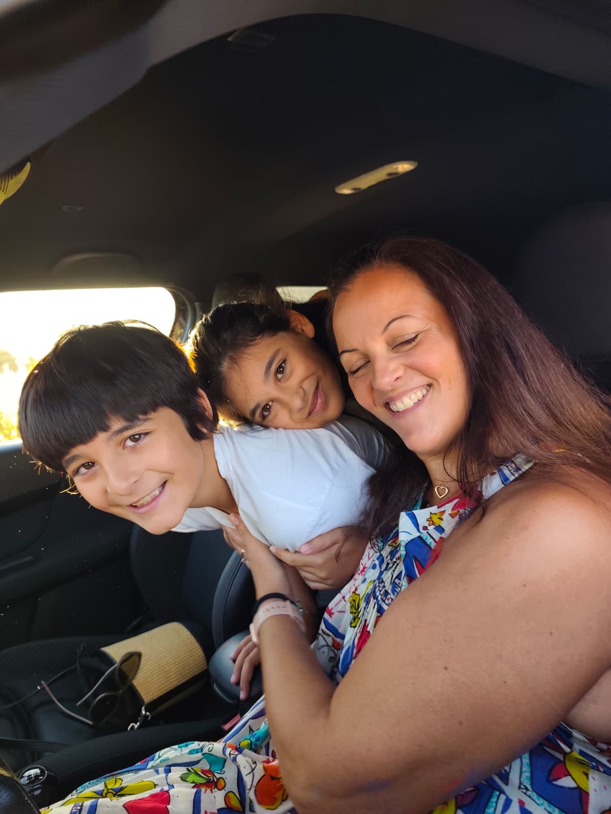 Mãe e filhos no carro, à chegada ao colégio